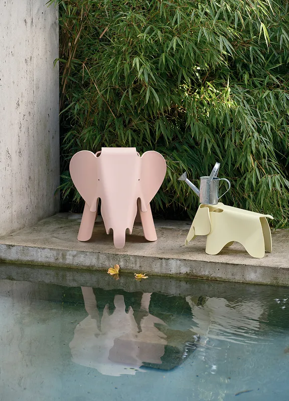 Vitra Eames Elephant, in rosa und gelb neben einem Pool